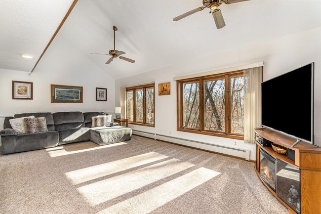 The main house has been meticulously updated & well-maintained. The great room is stunning with it's vaulted ceiling, large windows overlooking the views of the wooded lot. It also features two ceiling fans & a mini-split air conditioner. | Image 12