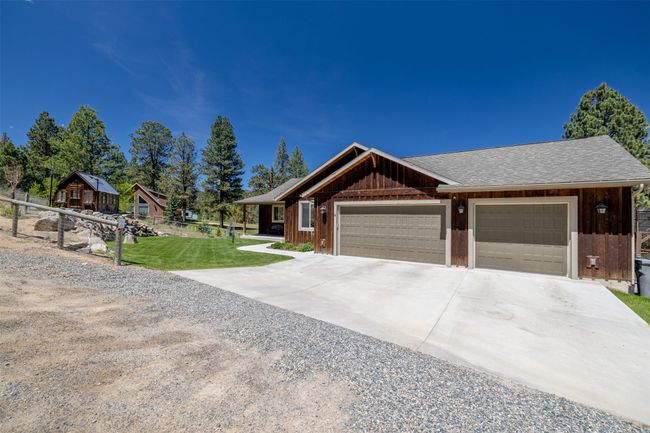 View of front facade with driveway, an attached garage, and a shingled roof | Image 49