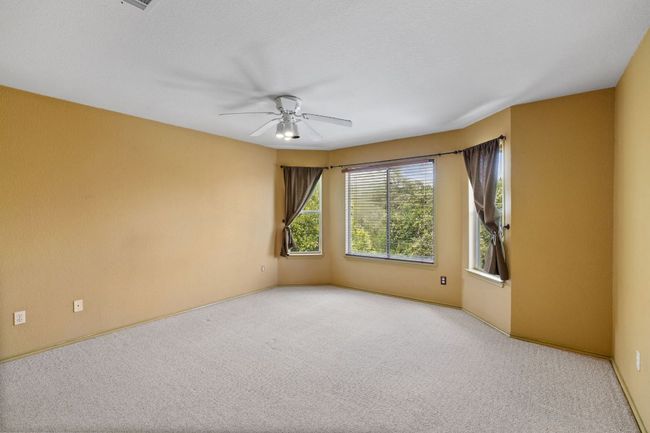 Carpeted spare room featuring a ceiling fan and baseboards | Image 25