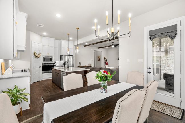 Dining area featuring a chandelier, dark wood-style flooring, recessed lighting, and a ceiling fan | Image 15