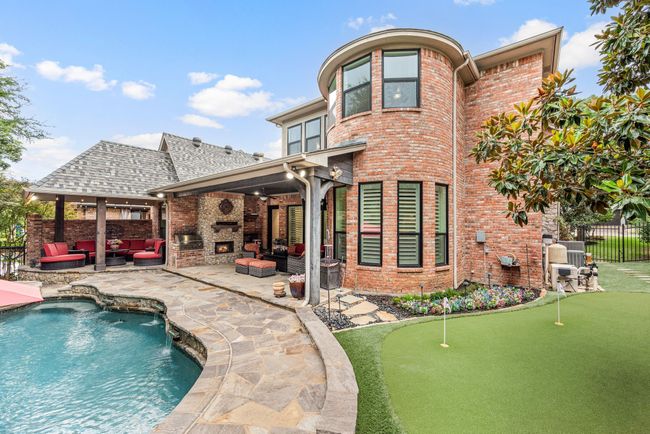 Practice your putting on the two hole putting green with synthetic turf or relax pool side. Two covered outdoor living spaces offer ample shade, a fan for warm days and infrared heaters and fireplace for cool evenings. | Image 32