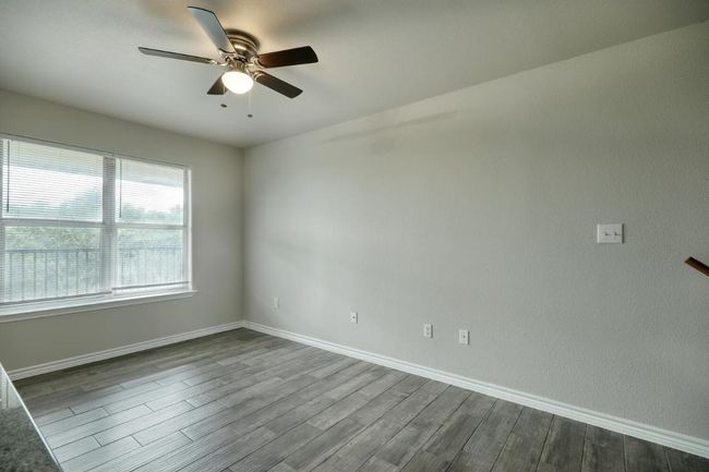 Empty room featuring dark wood-type flooring and a ceiling fan | Image 5