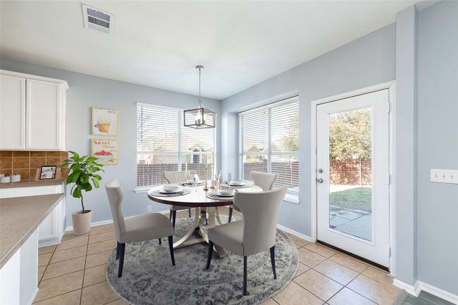 Dining area with light tile patterned flooring, visible vents, and baseboards | Image 6