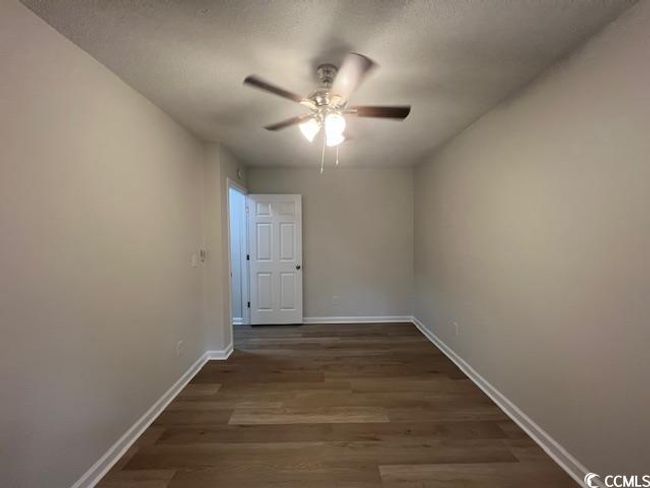 Empty room with baseboards, a ceiling fan, dark wood-style flooring, and a textured ceiling | Image 22
