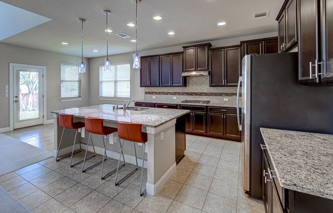 Kitchen with light tile patterned flooring, healthy amount of natural light, tasteful backsplash, a center island with sink, and recessed lighting | Image 7