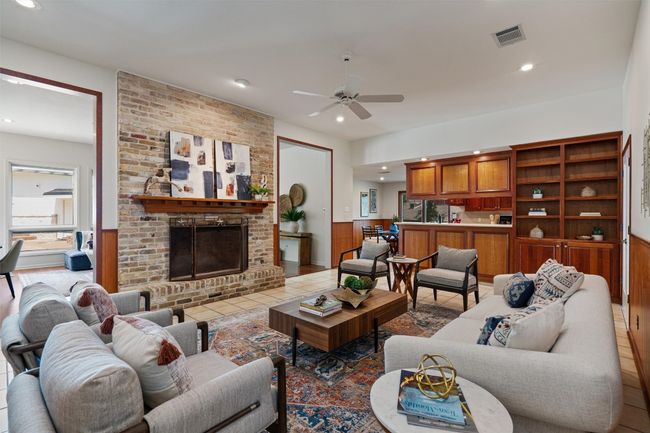 Another large living area is open to the kitchen and is anchored by a cozy brick fireplace | Image 13