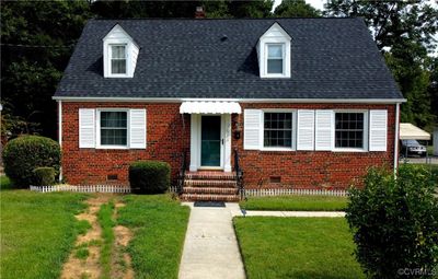 Brick Cape cod home featuring a front lawn | Image 1