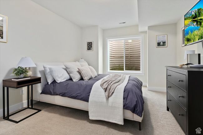 Bedroom featuring light colored carpet, baseboards, and visible vents | Image 30
