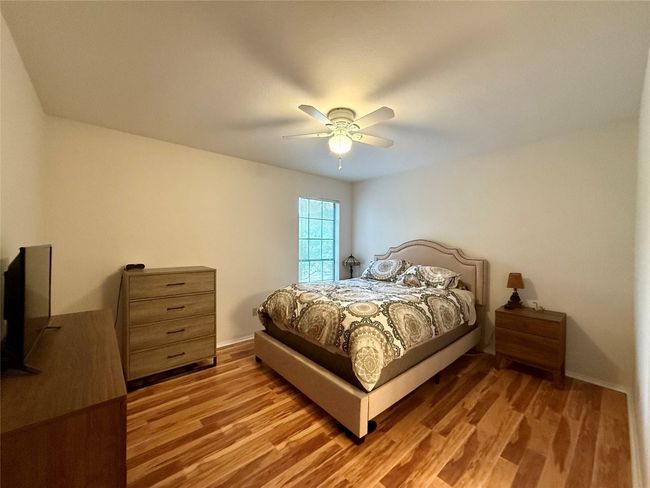 Bedroom with wood finished floors and ceiling fan | Image 10