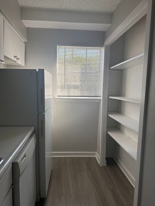 Laundry area with cabinet space, dark wood-style flooring, and baseboards | Image 8