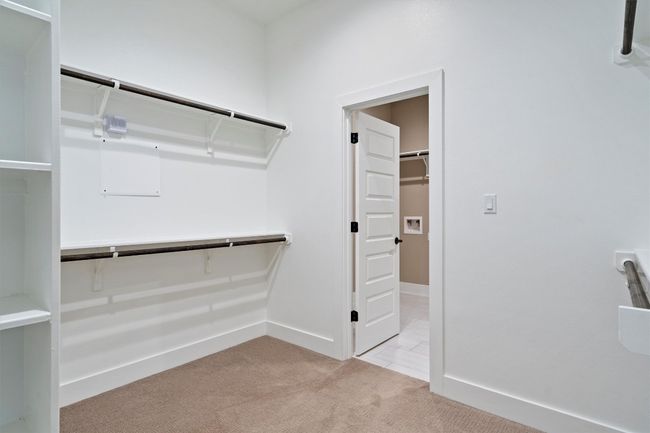 Walk in closet featuring light colored carpet | Image 18