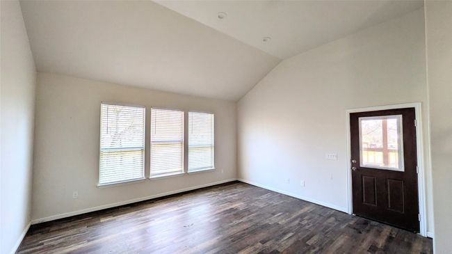 Unfurnished room featuring vaulted ceiling, dark wood-style flooring, and baseboards | Image 15