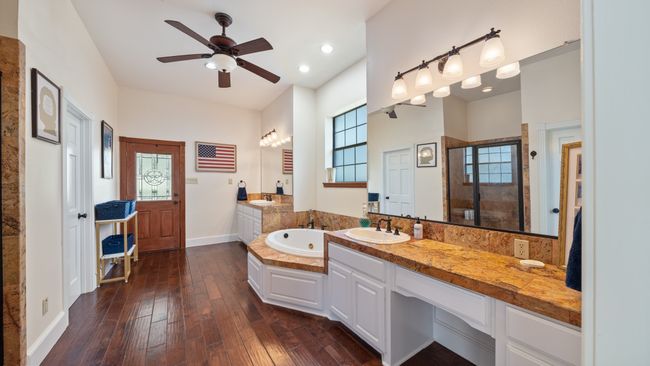 Bathroom with a shower stall, hardwood / wood-style flooring, a sink, and a ceiling fan | Image 19