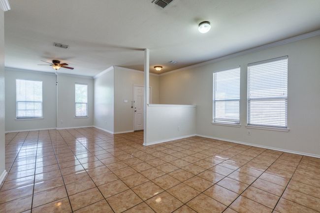 Unfurnished room with visible vents, baseboards, light tile patterned floors, a ceiling fan, and crown molding | Image 14