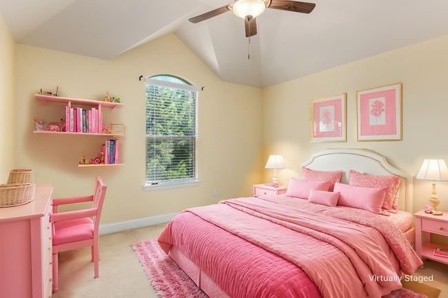Bedroom with light colored carpet, vaulted ceiling, a ceiling fan, and baseboards | Image 11