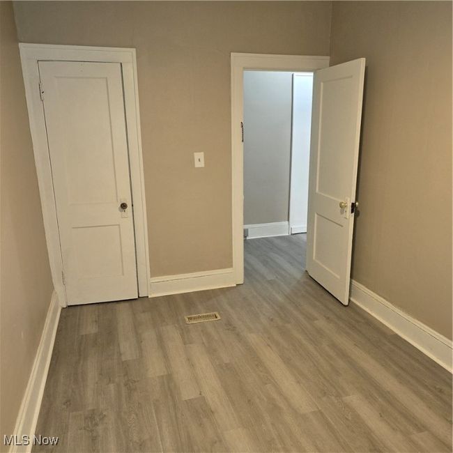 Alt shot. Empty room featuring baseboards, wood finished floors, and visible vents | Image 5