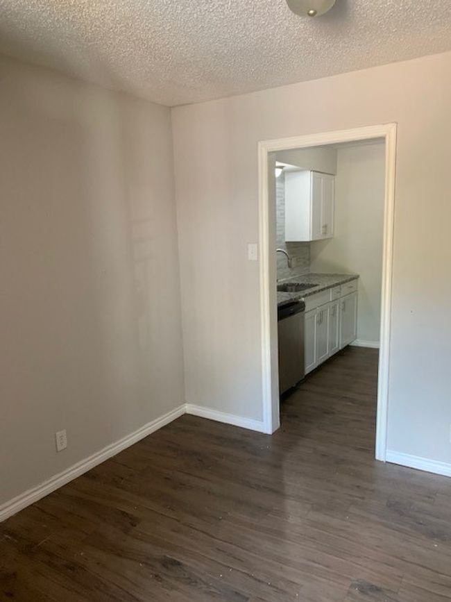 Unfurnished room featuring dark wood-type flooring, a sink, baseboards, and a textured ceiling | Image 6