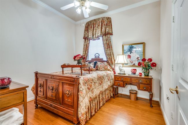 Bedroom with light wood finished floors, crown molding, and a ceiling fan | Image 14