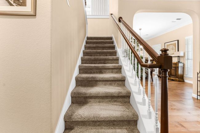 Stairway with wood finished floors, ornamental molding, arched walkways, and baseboards | Image 17