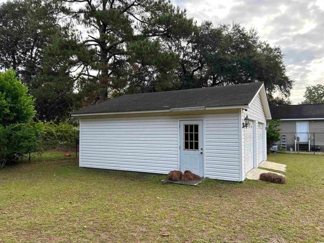View of outdoor structure with a yard and a garage | Image 14