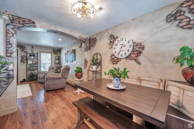 Dining space with a textured ceiling, arched walkways, and wood finished floors | Image 10