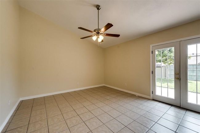 Empty room featuring french doors, a ceiling fan, vaulted ceiling, light tile patterned floors, and baseboards | Image 6