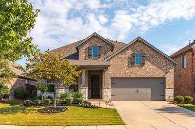 Craftsman-style house with a front yard and a garage | Image 1