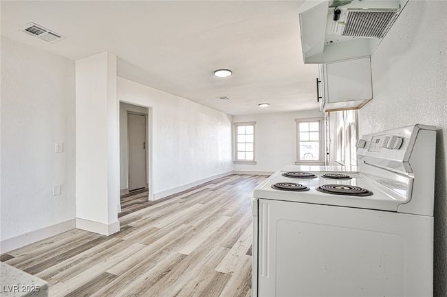 Kitchen with white electric range, washer / dryer, and light wood finished floors | Image 7