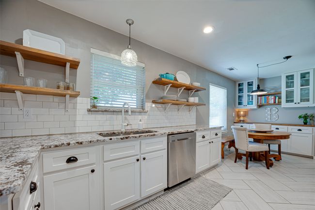 Kitchen with open shelves, dishwasher, backsplash, white cabinets, and recessed lighting | Image 12