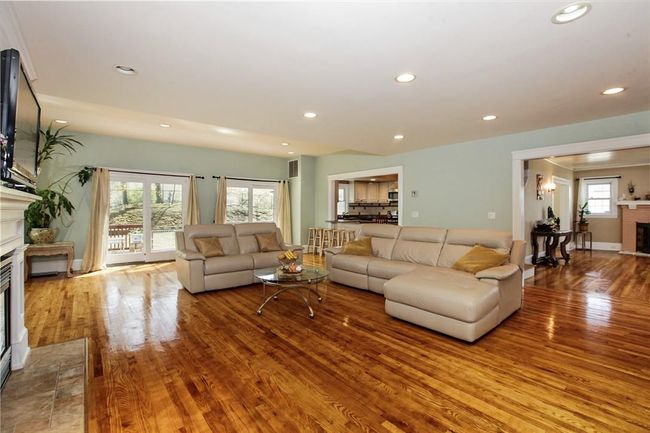 A view of family room showing sliders to deck, kitchen and living room. | Image 7