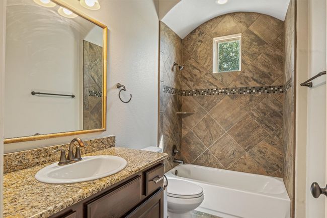 Casita ensuite full bathroom featuring tub / shower combination, vanity with granite counters and storage | Image 11