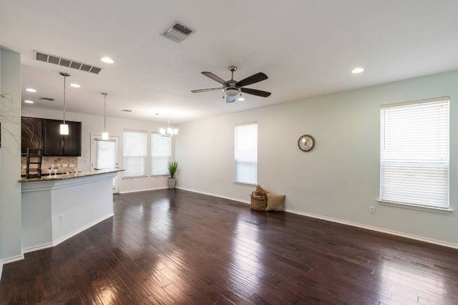 Unfurnished living room featuring ceiling fan, a chandelier, recessed lighting, and dark wood-type flooring | Image 19