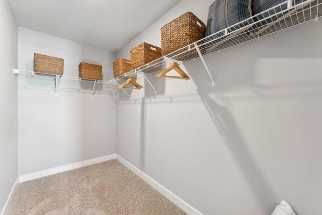 The large walk in closet in the upper secondary suite. Photo of model home, colors and finishes will vary. | Image 24