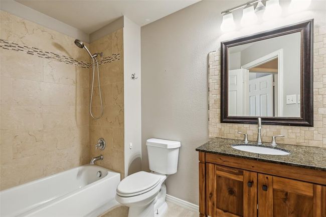 Full bathroom featuring tiled shower / bath, vanity, and toilet | Image 26