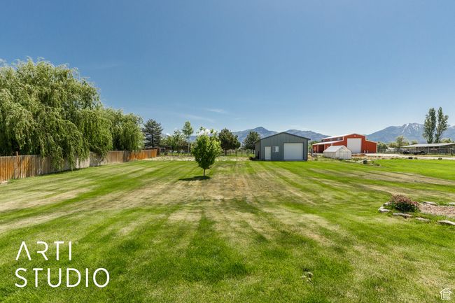 View of yard with an outbuilding, a mountain view, and a detached garage | Image 42