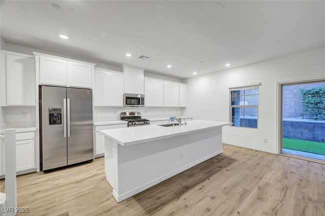 Kitchen featuring stainless steel appliances, a center island with sink, light wood-style flooring, and a sink | Image 13