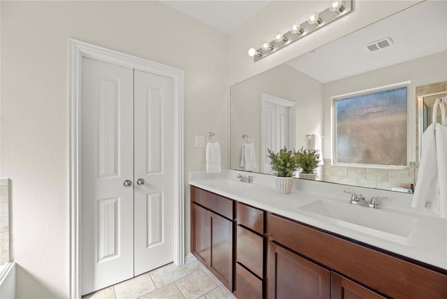 A seemingly endless mirror stretches the entire length of the countertops in the primary en suite. | Image 13