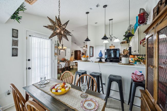 Dining space with a textured ceiling, light tile patterned floors, and vaulted ceiling | Image 15