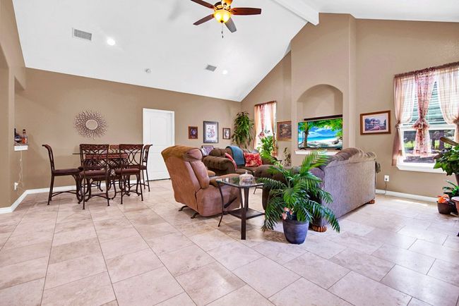 Living room featuring high vaulted ceiling, ceiling fan. | Image 11