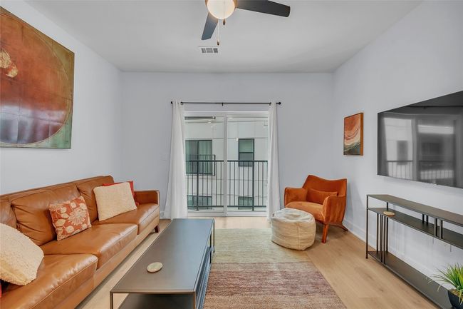 Living area with a ceiling fan and wood finished floors | Image 10