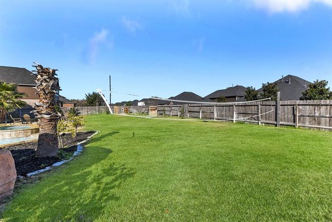 This view showcases the side yard and the generous space it offers. It provides plenty of room to expand on existing activities or create new ones, whether it's adding more outdoor features or starting a garden. This area offers the perfect extension of your living space, ideal for relaxation, entertaining, or enjoying the outdoors. | Image 46