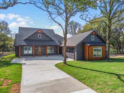 View of front of property featuring a front yard and a garage | Image 1