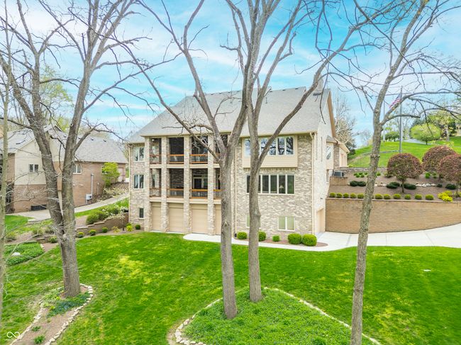 rear view of house featuring a lawn, stone siding, and a balcony | Image 6
