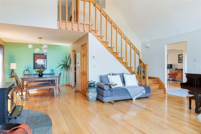 Living room featuring hardwood / wood-style floors, visible vents, and stairway | Image 23