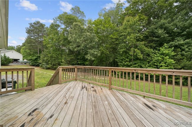 Deck featuring a lawn and view of scattered trees | Image 30