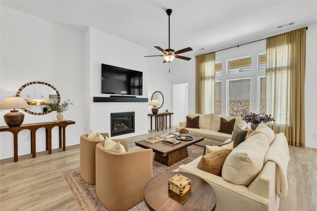 Living room featuring light wood-style flooring, a ceiling fan, a fireplace, and baseboards | Image 13