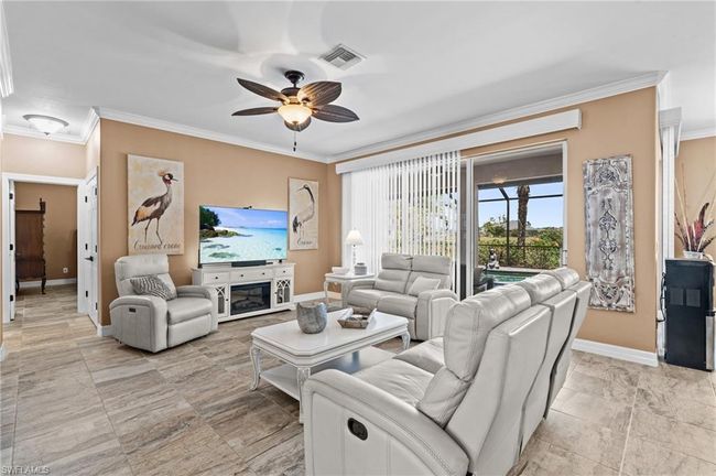 Living area featuring ceiling fan, baseboards, and crown molding | Image 17