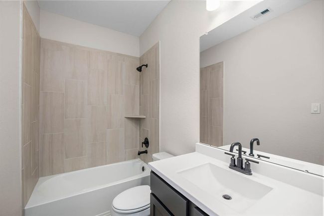 This secondary bathroom has a stylish vanity with lots of storage. The tub-shower combo is very convenient. Whether you're freshening up in the morning or unwinding after a long day, this bathroom is the perfect setting for relaxation and self-care. | Image 7
