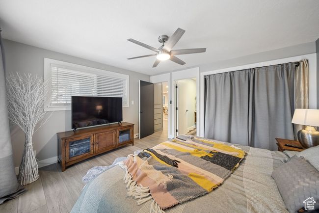 Bedroom with light wood-style flooring, ceiling fan, and baseboards | Image 10