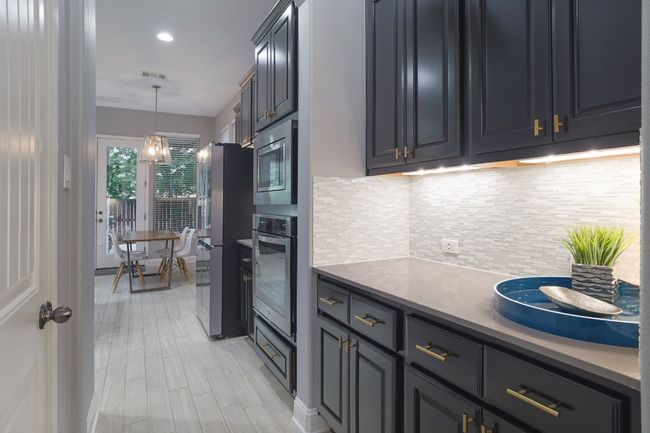 Kitchen featuring appliances with stainless steel finishes, tasteful backsplash, hanging light fixtures, and light countertops | Image 10